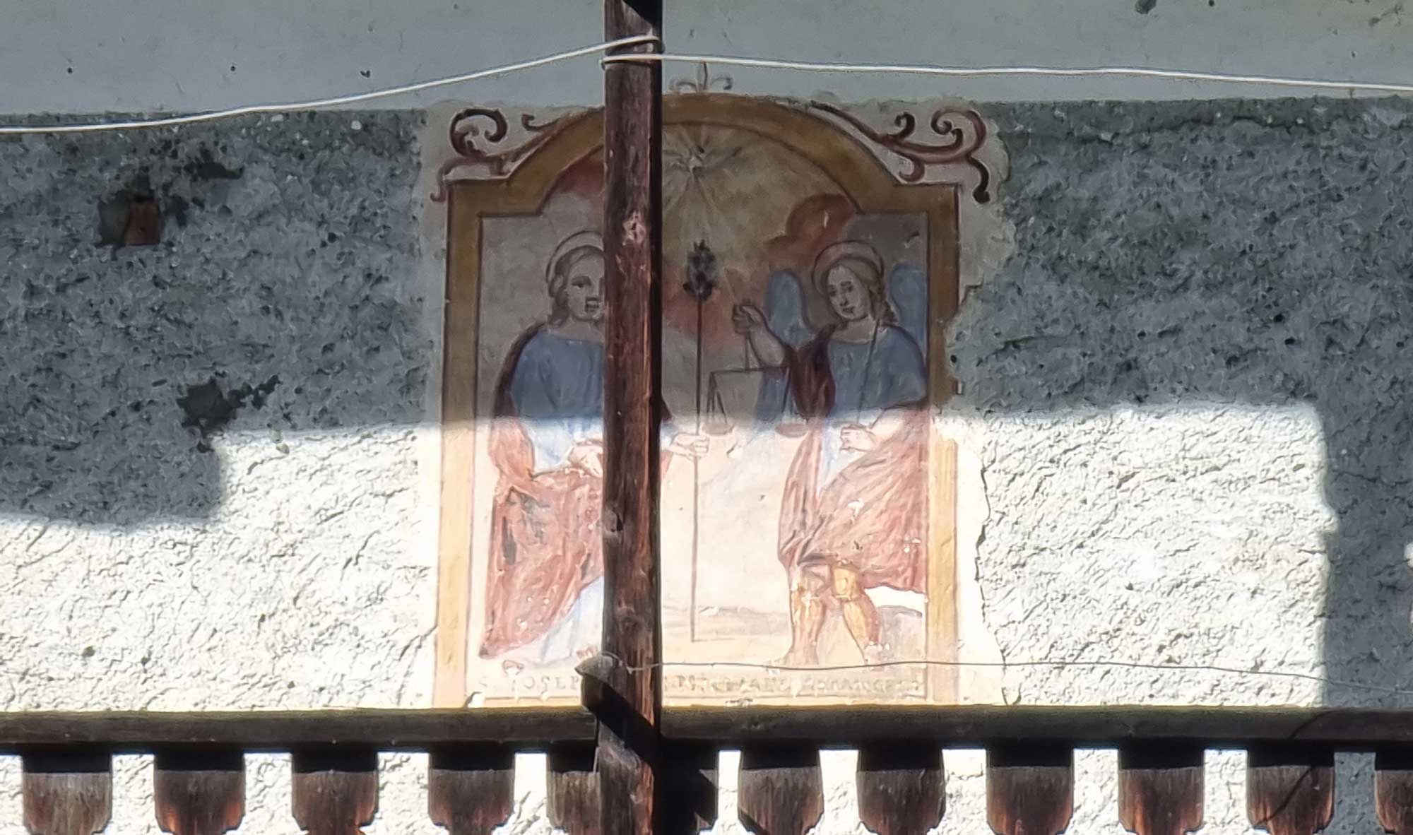 San Giuseppe, sulla sinistra, vestito di azzurro e ammantato di bruno, regge il lungo bastone fiorito che divide idealmente la composizione in senso verticale. In alto, tra le nubi, lo Spirito Santo, sotto forma della mistica colomba, irradia raggi di luce. Sulla destra, l’Arcangelo Michele, capo della schiera celeste, è rappresentato secondo l’iconografia tradizionale mentre regge con la sinistra la spada con la quale sconfiggerà, nel giorno del Giudizio, gli angeli ribelli, e con la destra la bilancia con due anime posate sui piatti, allusione al suo compito di ‘pesatore di anime’.